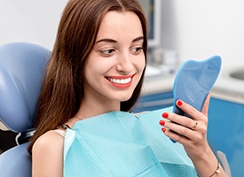 Woman looking at her flawless smile in mirror