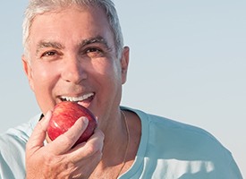 Senior man eating an apple