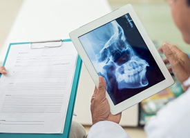 Dentist looking at skull x-ray on tablet